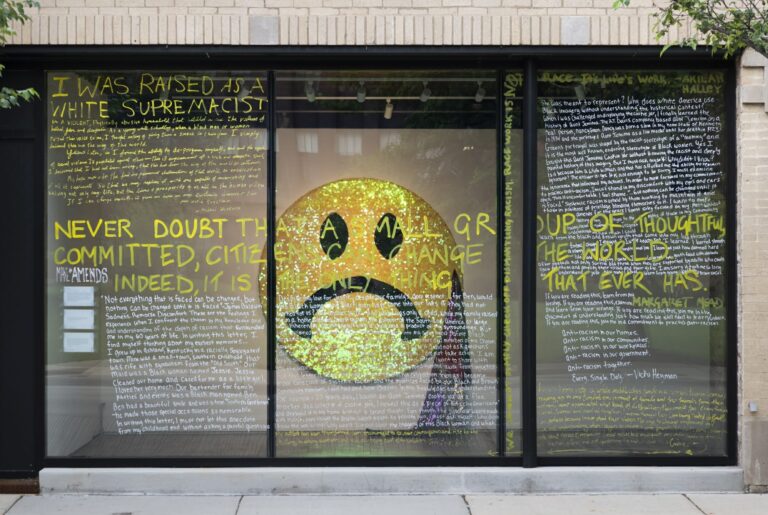 the windows with writing on the front of the Madison Museum of Contemporary Art, showing part of the AMENDs exhibition inside the building