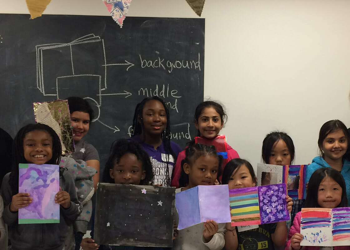 Group of children holding their artwork and enjoying art at MMoCA.