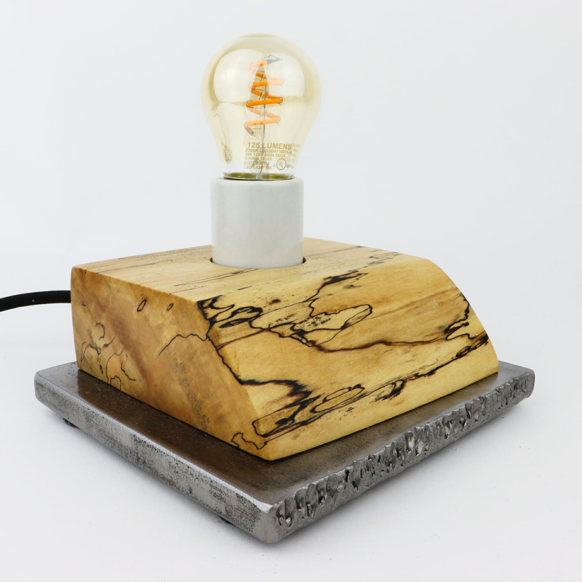 a lightbulb on wood and stone