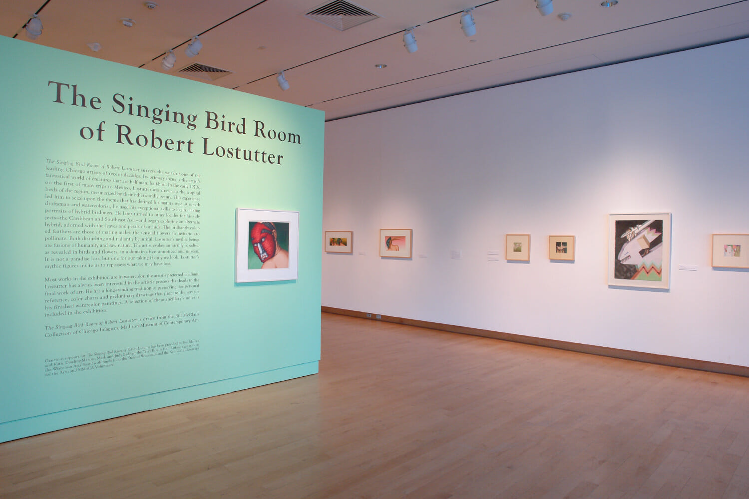 installation view of "The Singing Bird Rooms of Robert Lostutter" showing part of the title wall text and framed artworks hanging across the wall