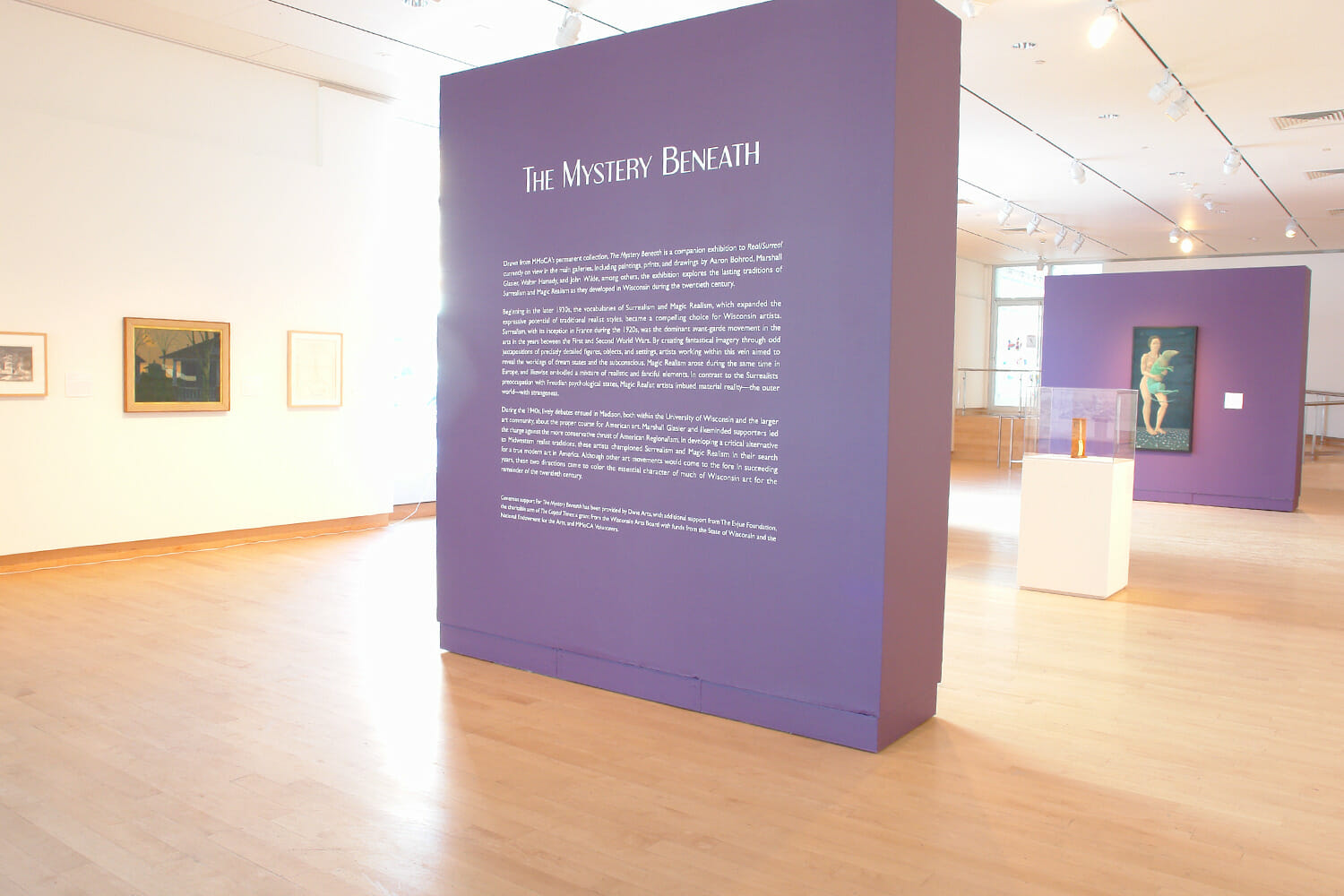 installation view of "the mystery beneath" showing the title wall text