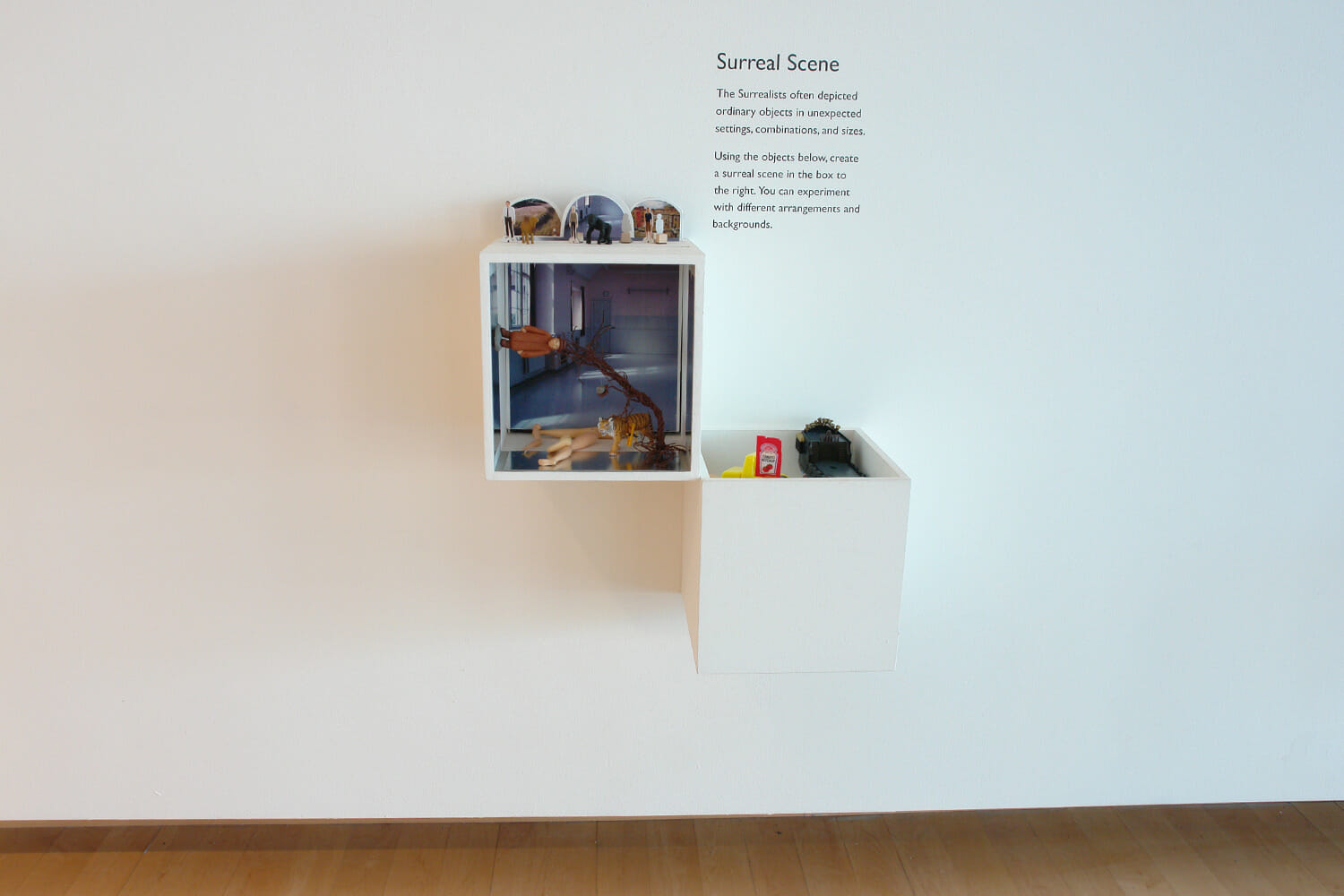 installation view of "the mystery beneath" showing an interactive activity allowing visitors to create a scene in a box using provided supplies and figurines