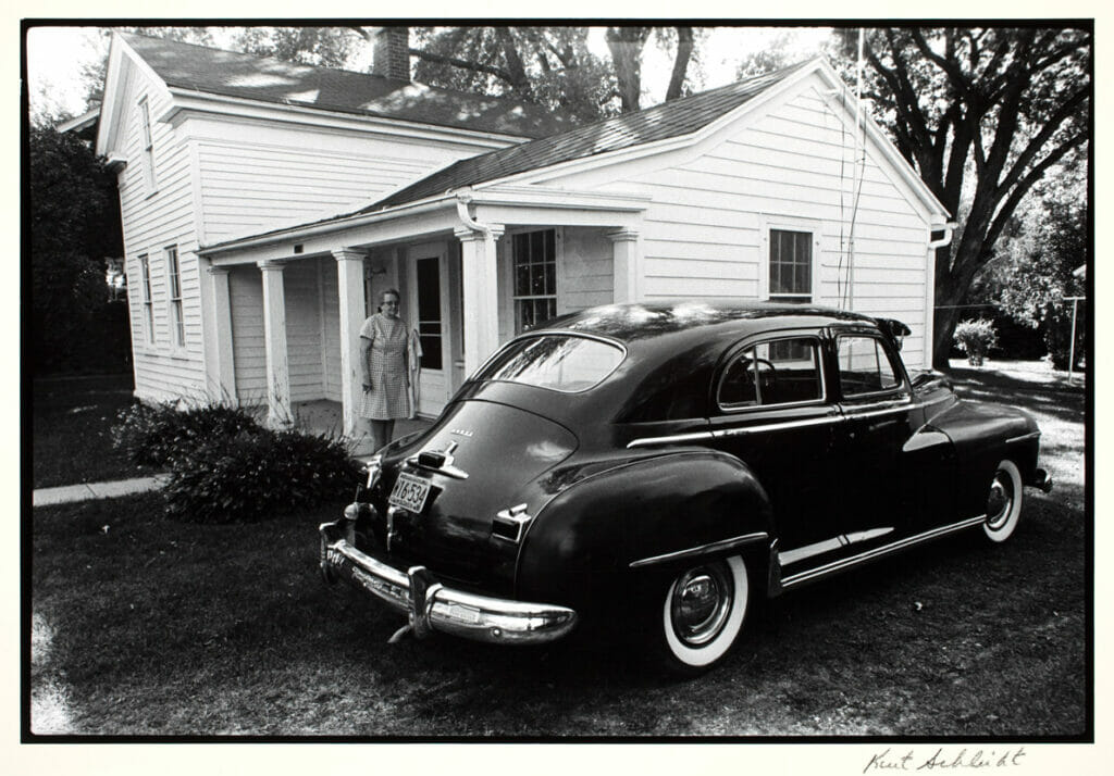 Lady with Old Car, Sauk City, Wisconsin. Artist: Kurt Schlicht. Date: 1971. Medium: photograph.