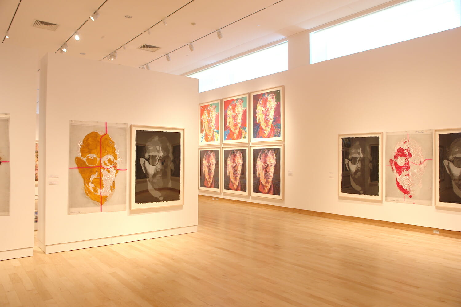 installation view of the Chuck Close Prints exhibition, featuring framed artworks on several different walls in a gallery space