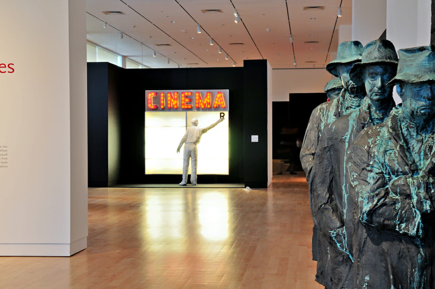 gallery installation view of George Segal: Street Scenes, featuring a variety of sculptures, including a sculpture showing at least three people lined up behind each other