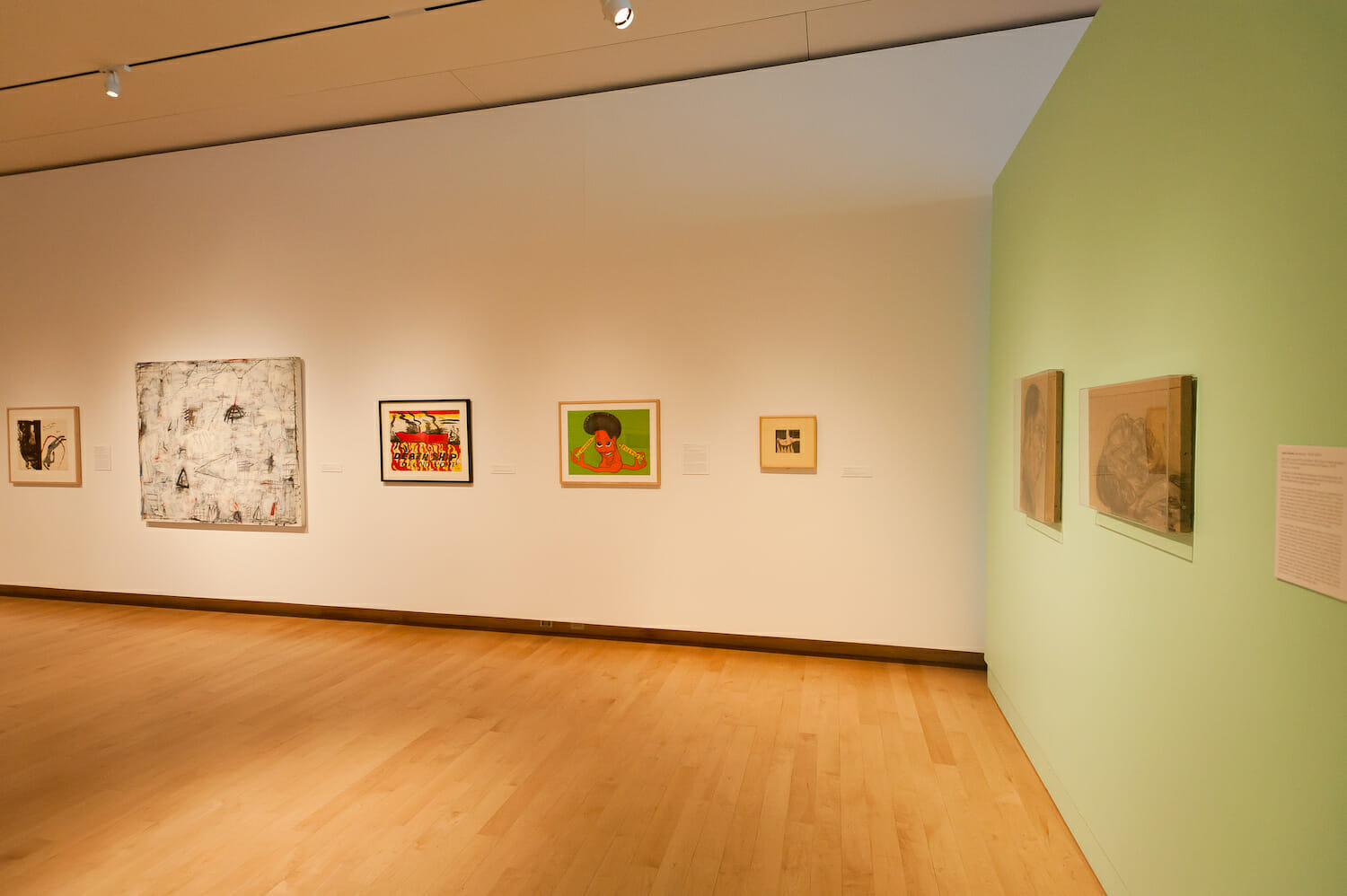 installation view of the exhibition Chicago School featuring framed artworks hanging vertically across walls