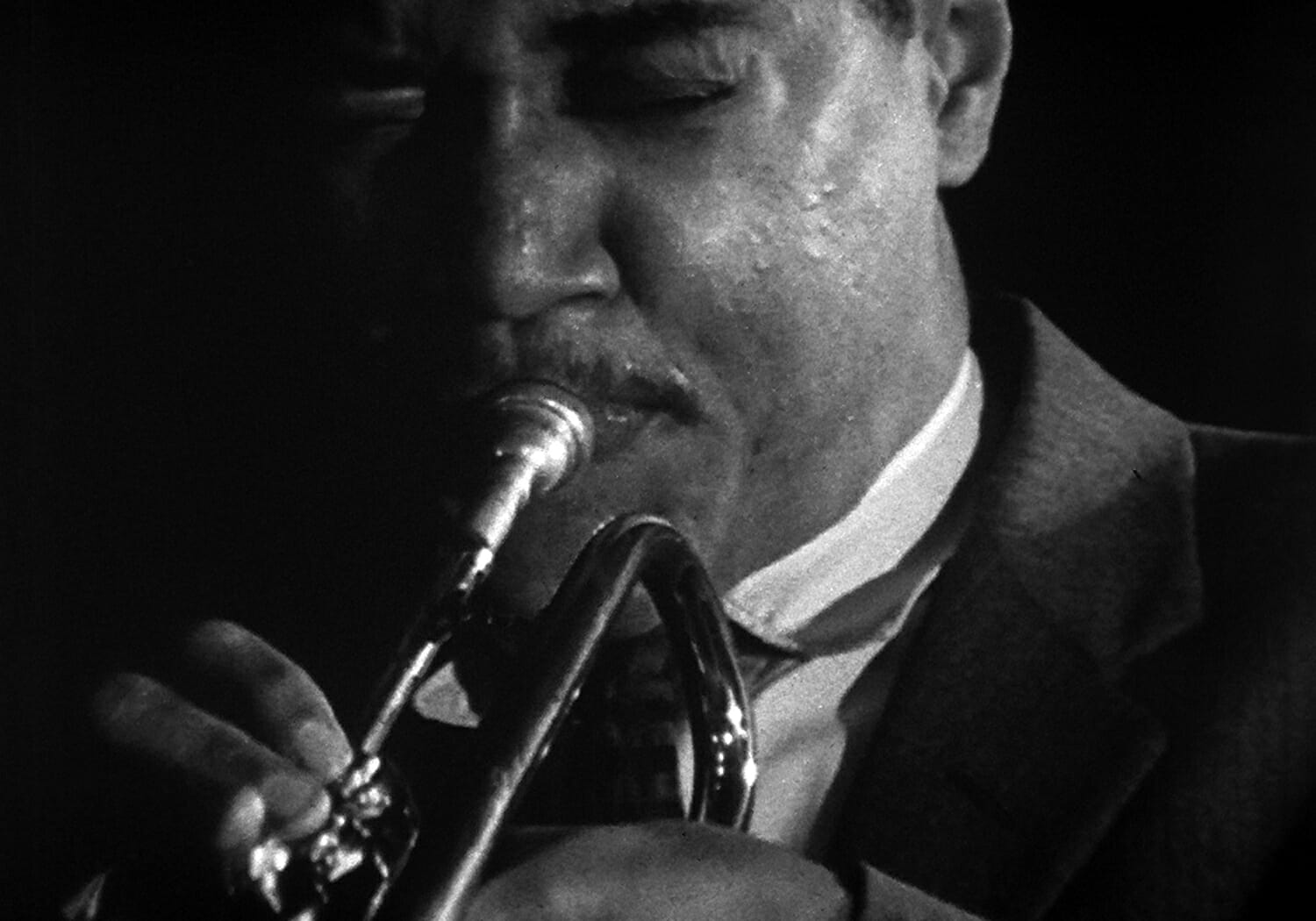 film still from The Cry of Jazz, showing a musician playing an instrument, possibly a trumpet