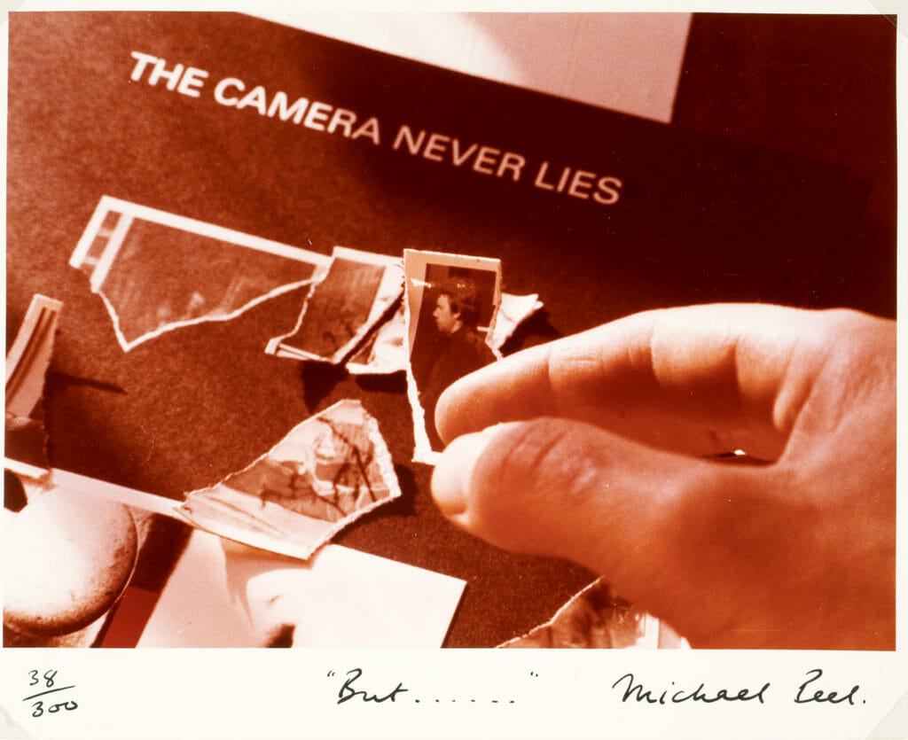 photograph depicting a hand hovering over a ripped photo or piece of paper