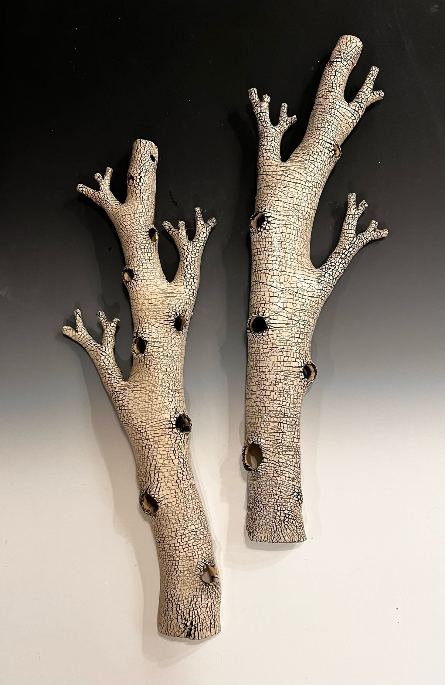 ceramic tree branches against a gradient.