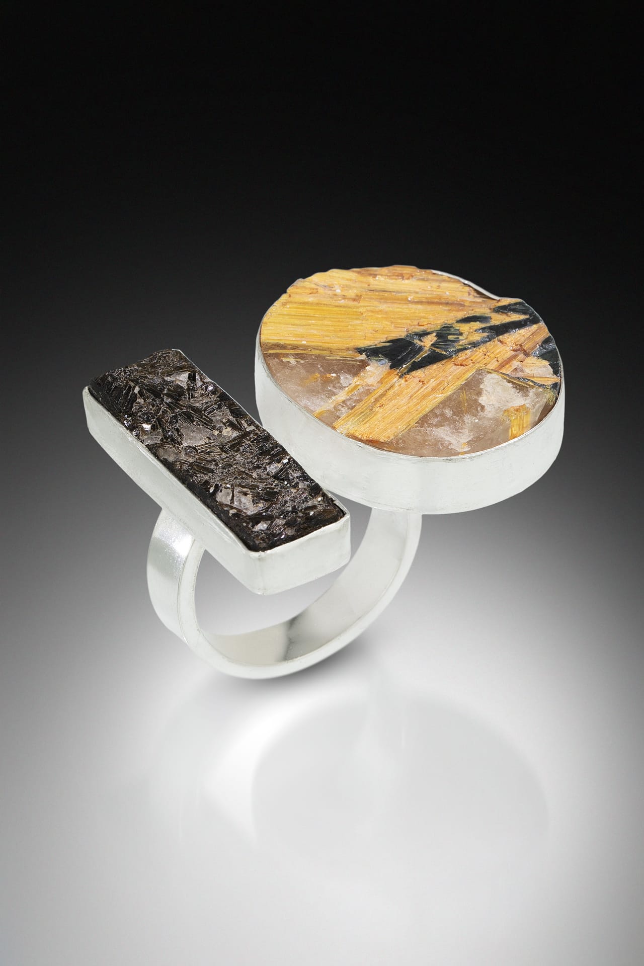 a silver ring with two large wood like insets.