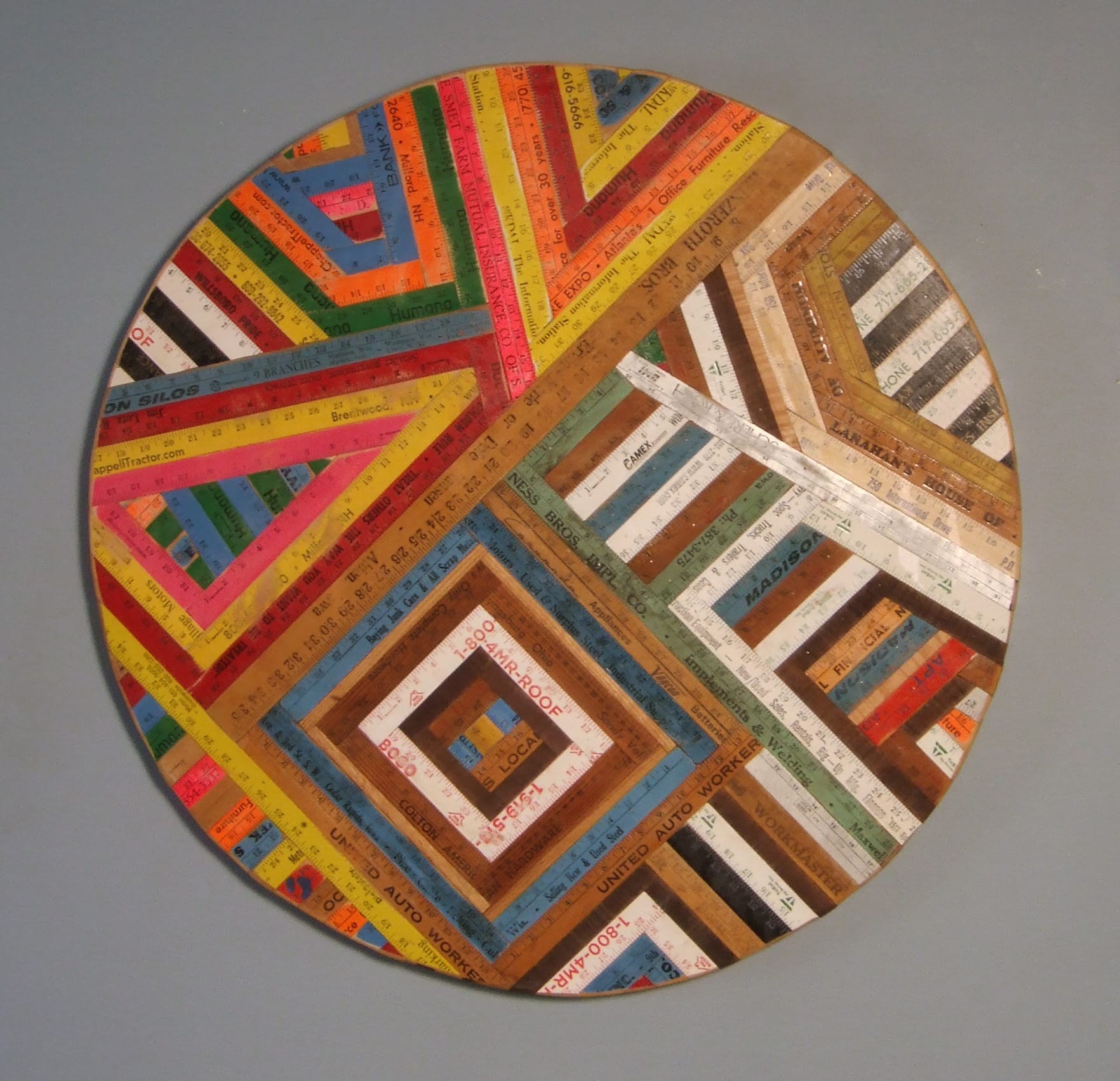 a circular painting with multi color even lined abstraction.