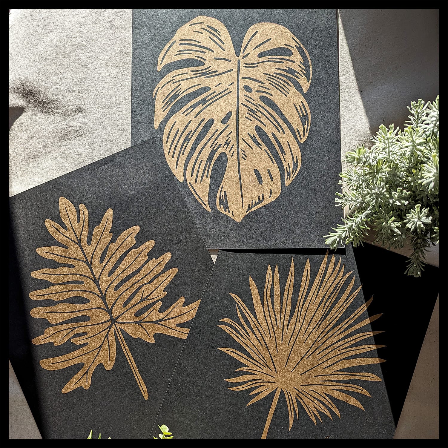 gold botanical prints on black paper.