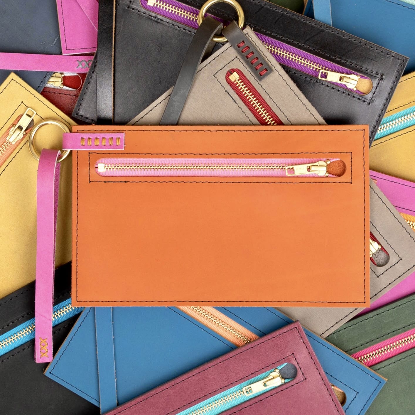 a collection of brightly colored leather clutches.