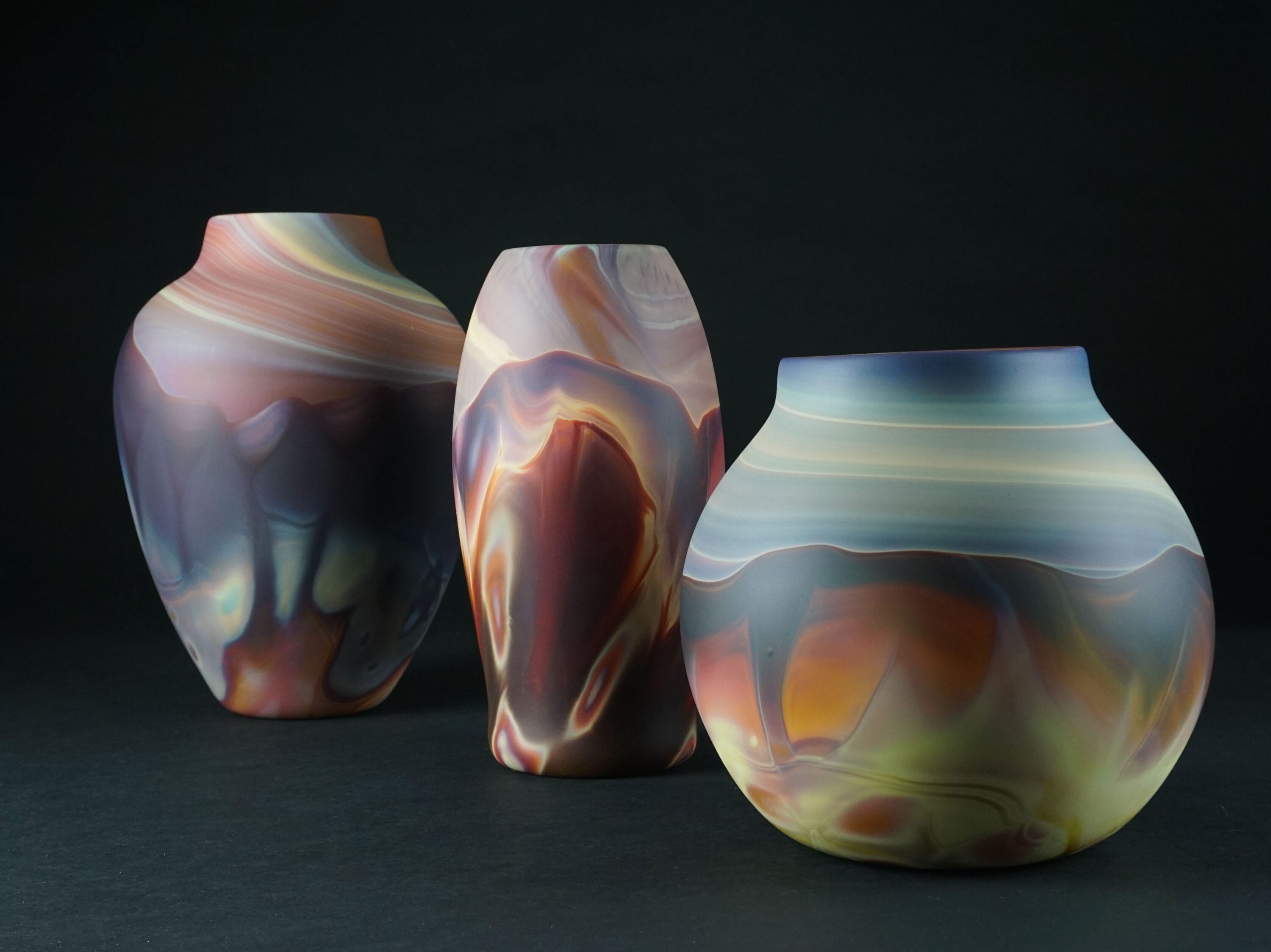 three multicolored glass vessels.