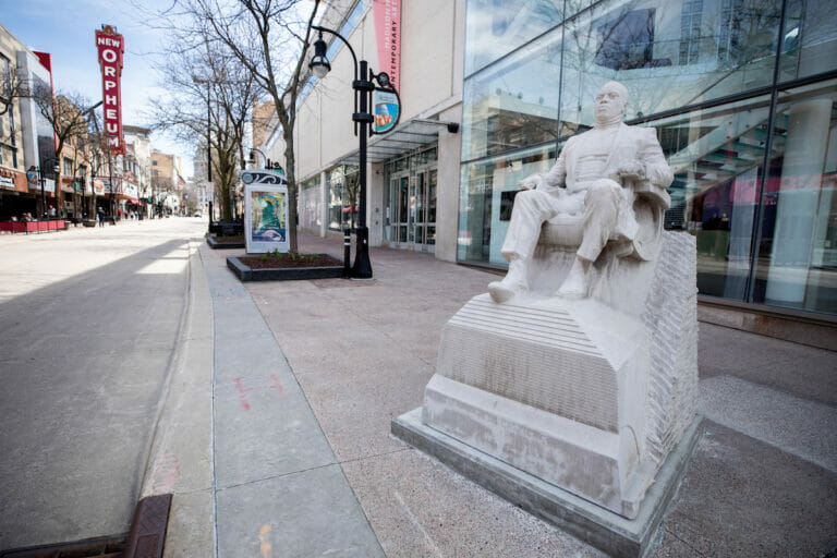 Monument showing a man seated in a barber's chair on State Street in front of the museum.