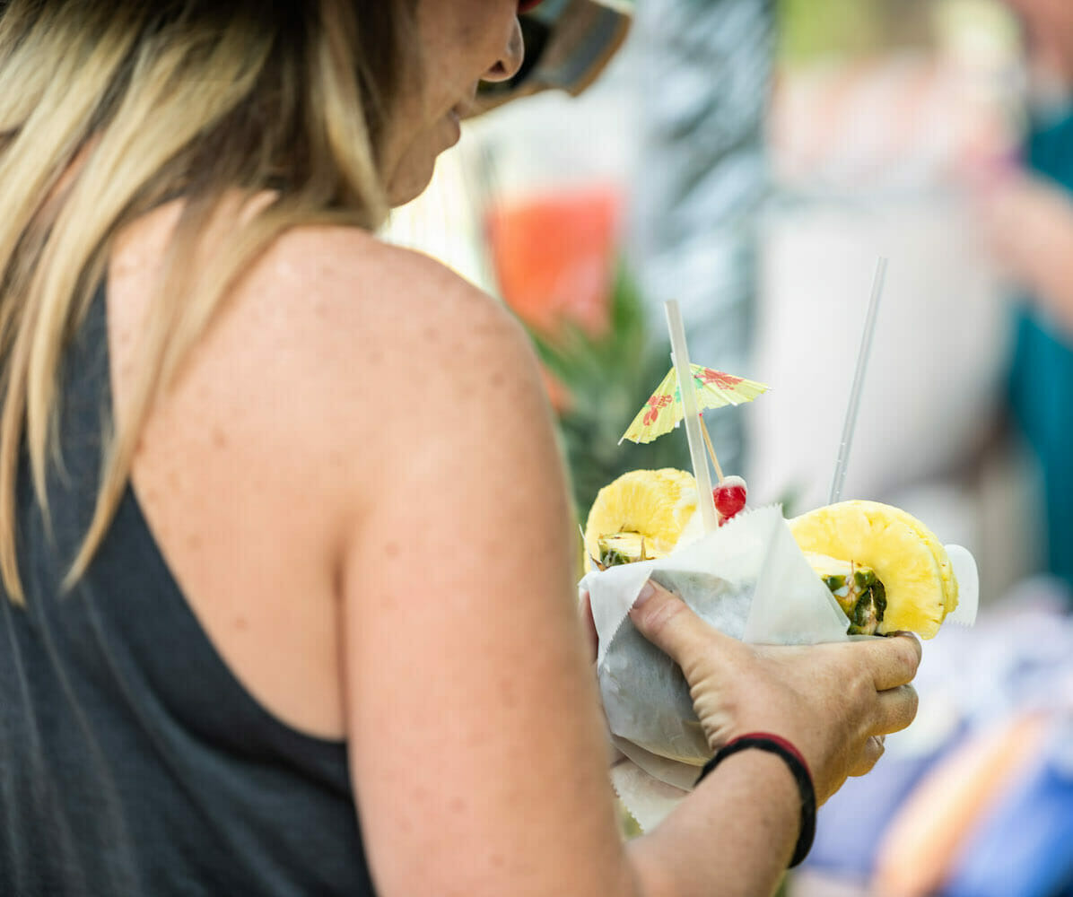 A person holding a pina colada.