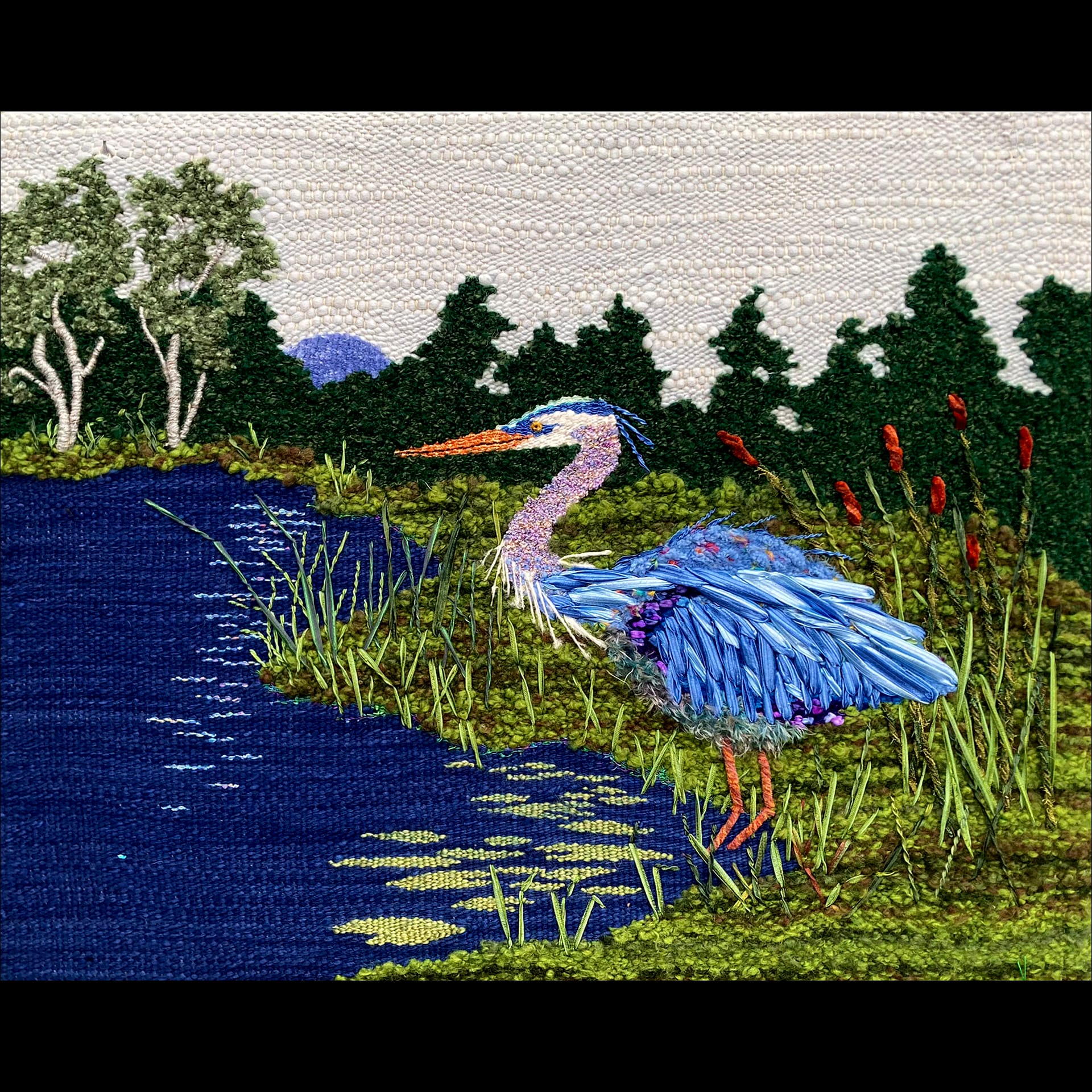 A felt and embroidered landscape with a blue heron.