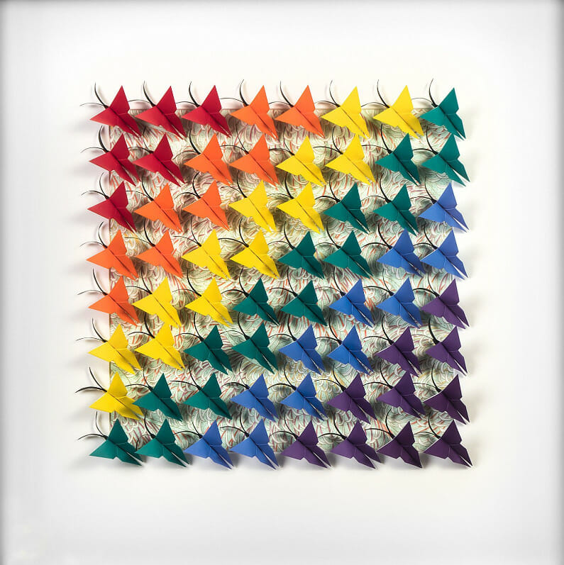 Framed artwork with origami butterfly arranged in a rainbow pattern.