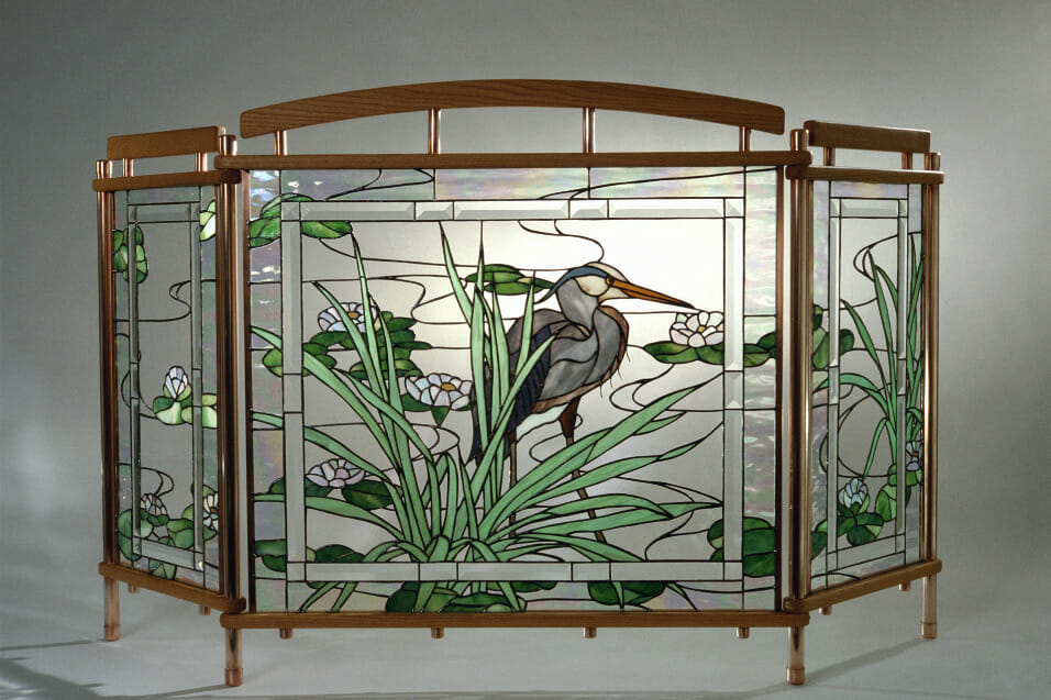 Glass art or screen depicting a crane in water.