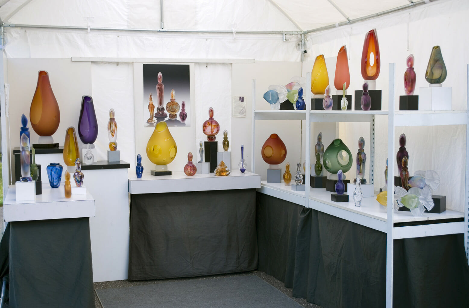 Art fair booth with various glass vases on display.