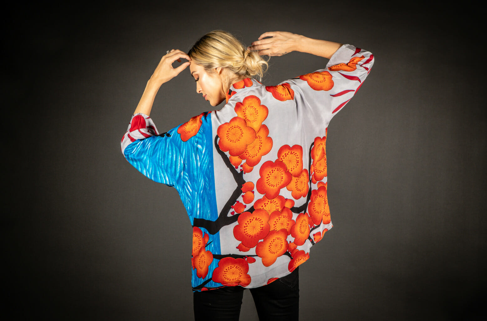 Person wearing and showing the back of a silk shirt with a blossom design.