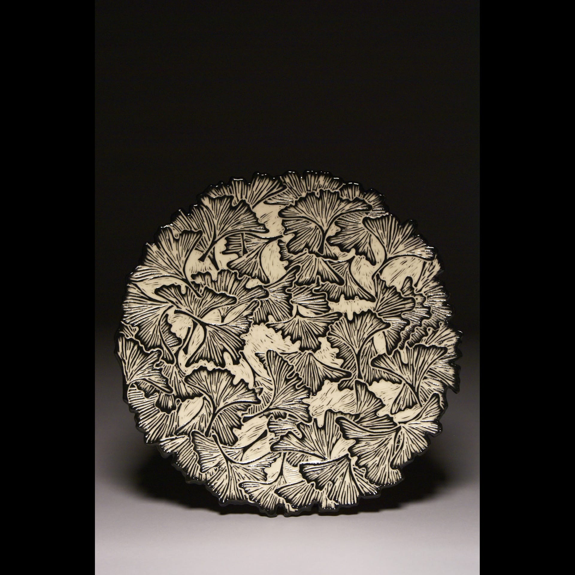 A black and white ceramic plate with floral patterns.