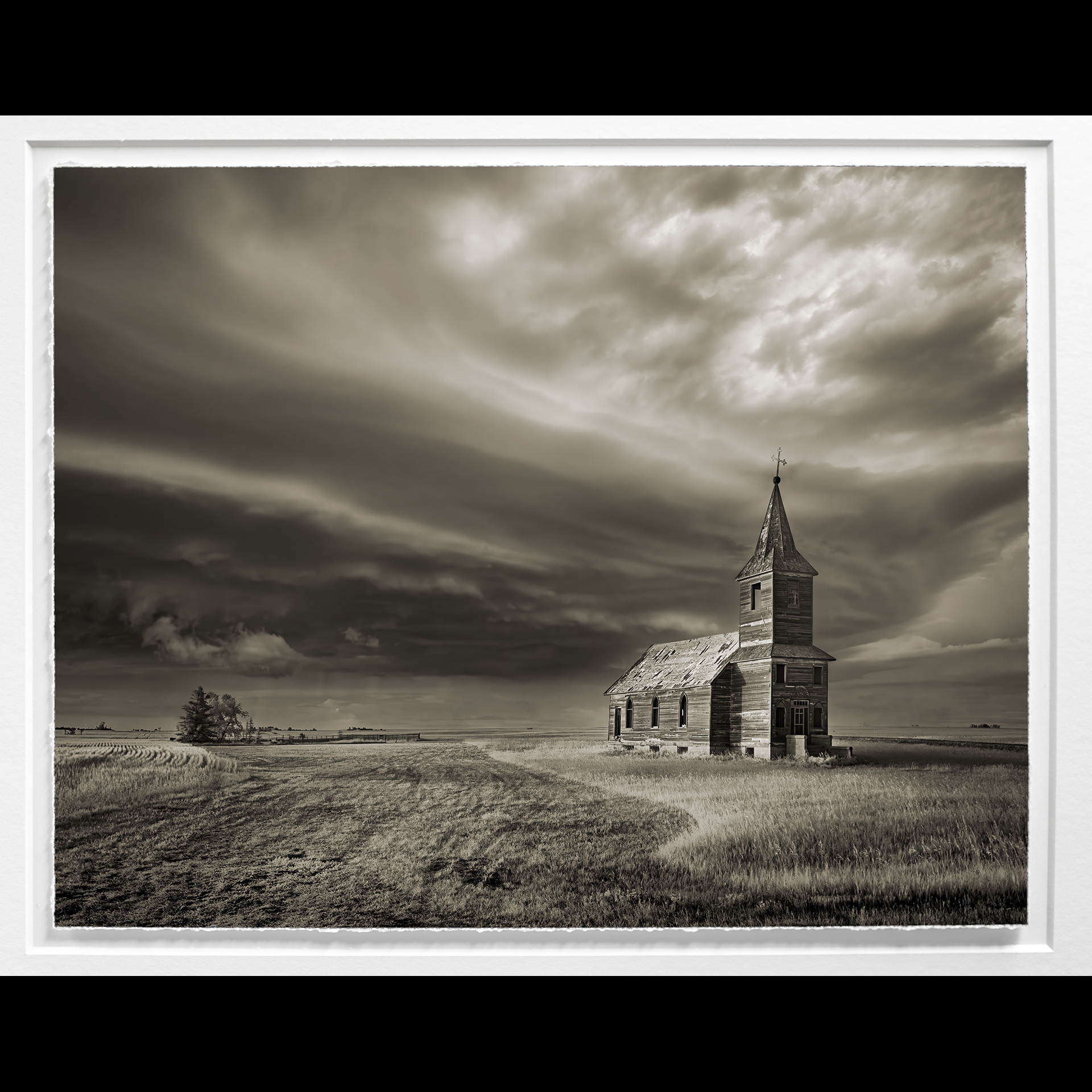 A sepia printed photograph of a church in a field.