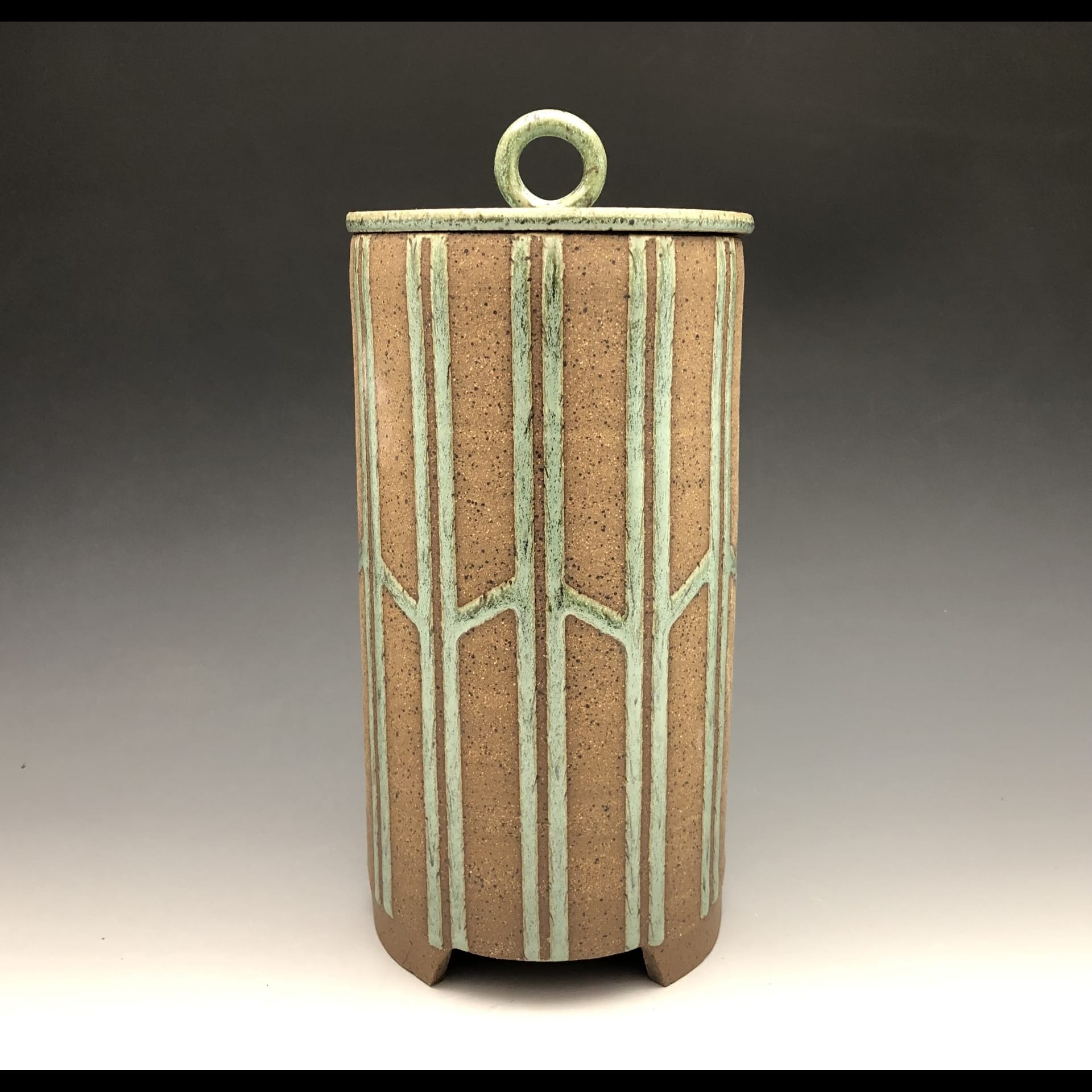 A ceramic cylinder with a lid.