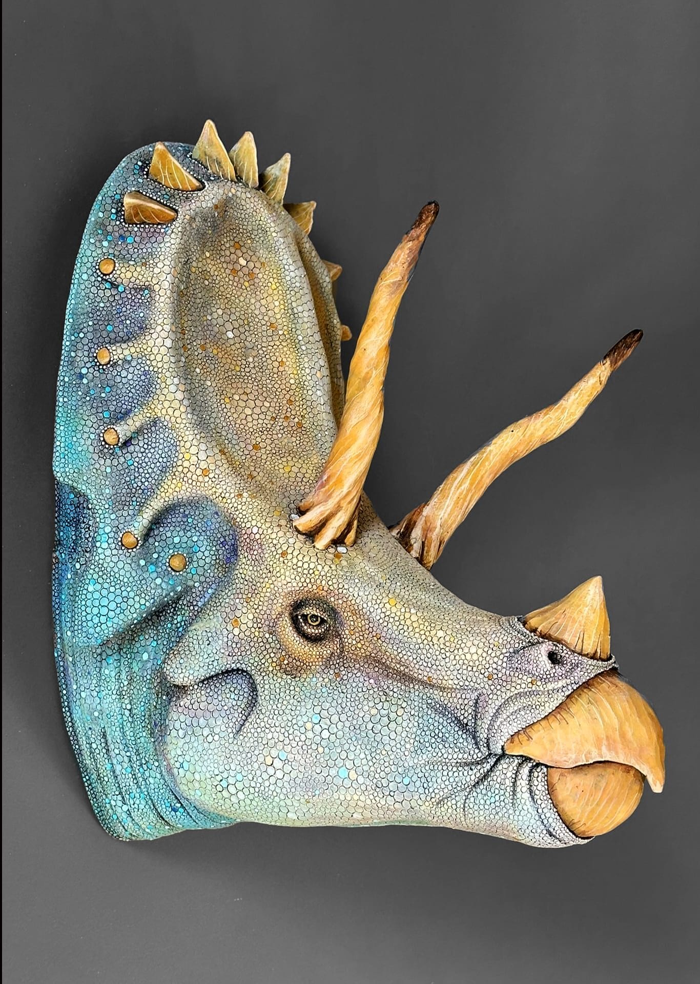 A ceramic sculpture of a dinosaur head.