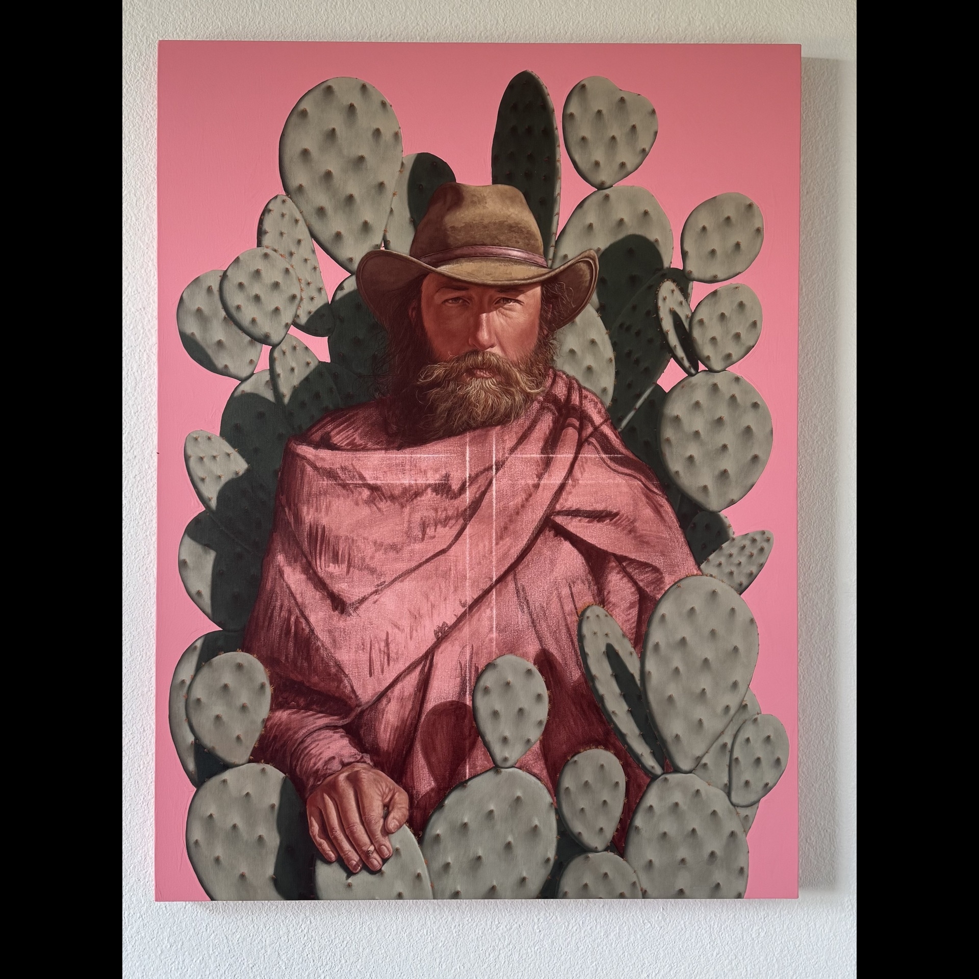 A man wearing pink inside of cactuses.