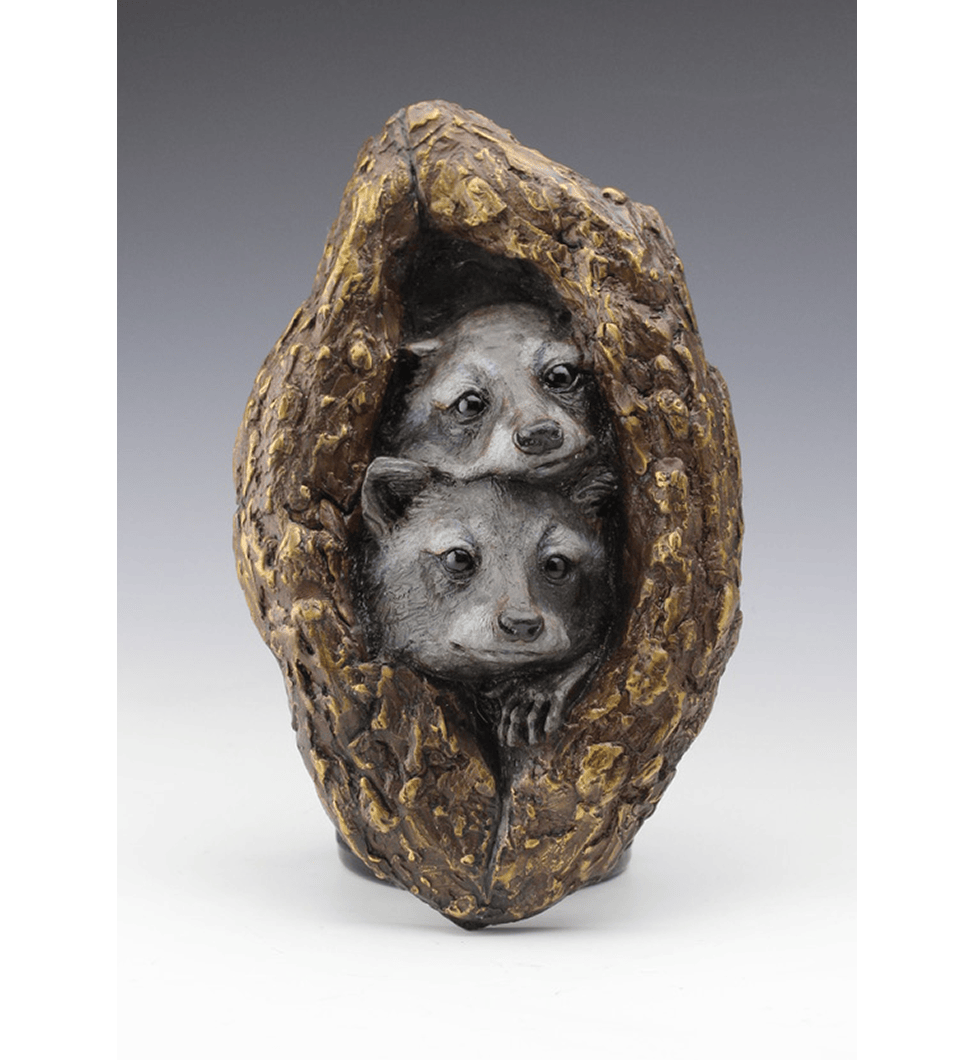 Sculpture of two racoon in wood.