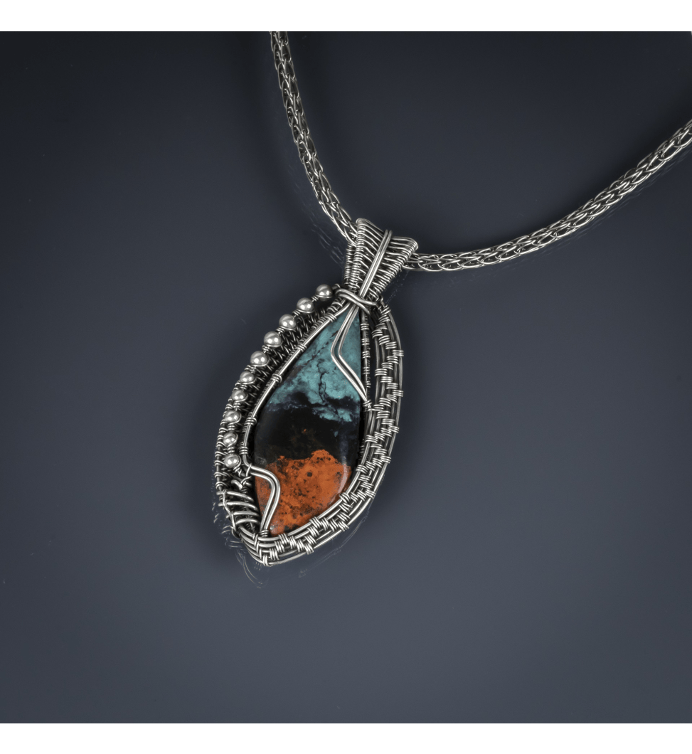 a silver pendant with a colorful stone.
