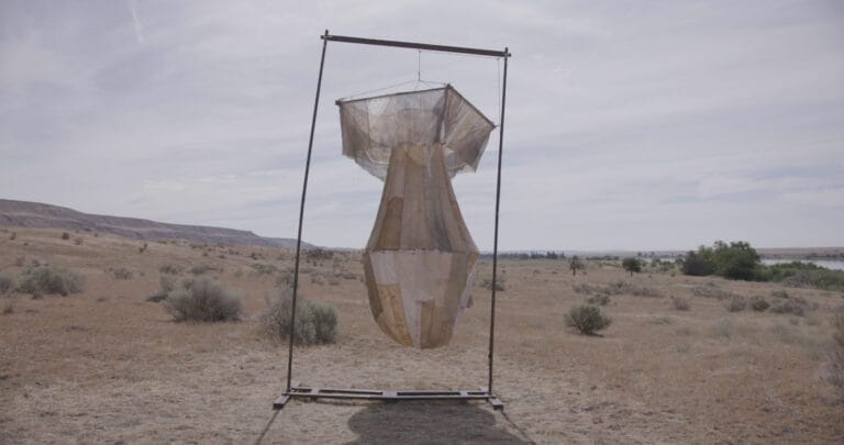 A sculptural form hanging from a beam in the dessert.