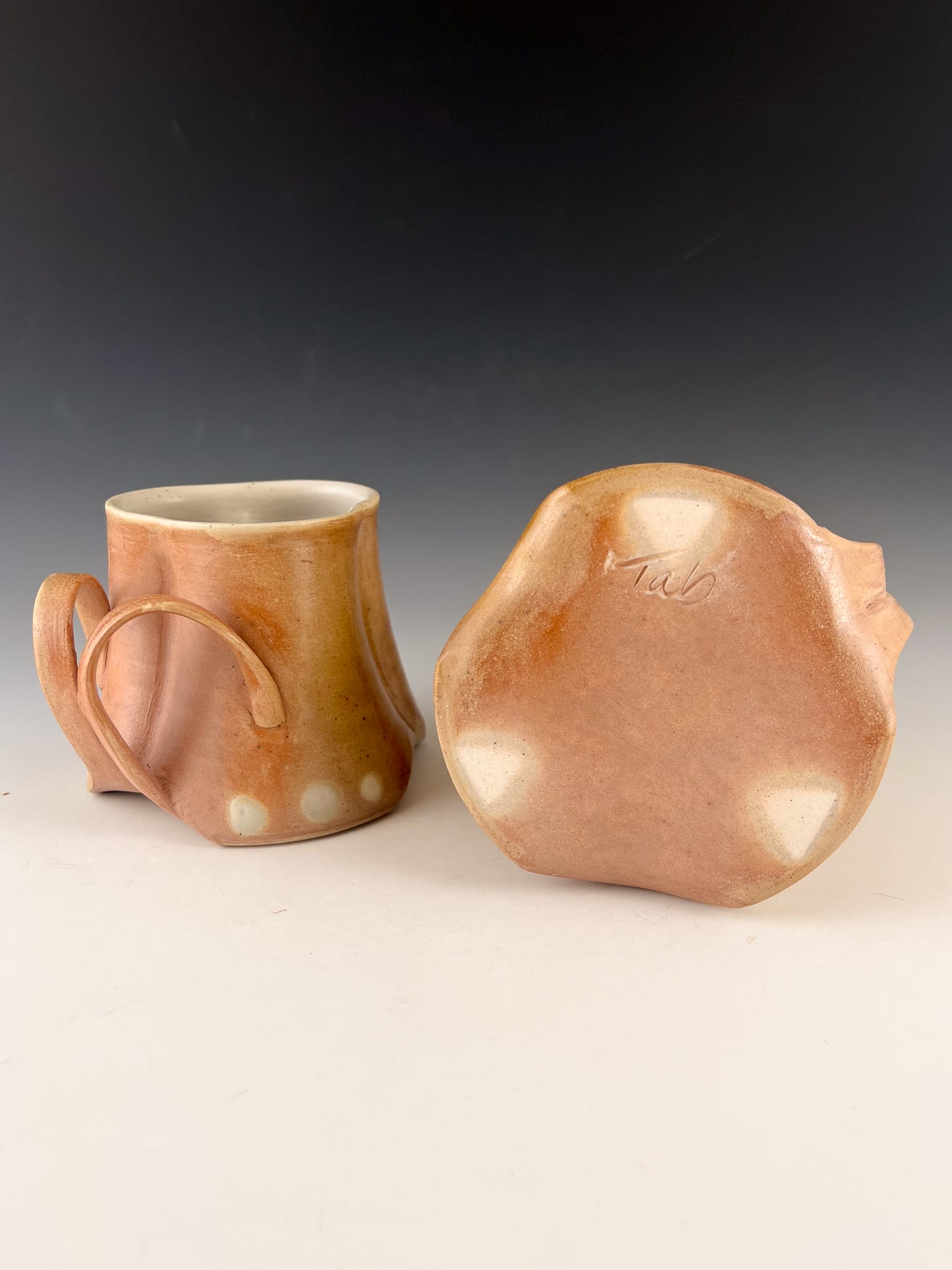 Two hand sculpted tan mugs.