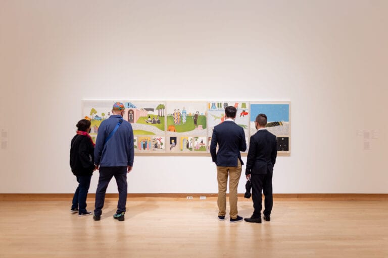 Four figures in a gallery looking at a painting.