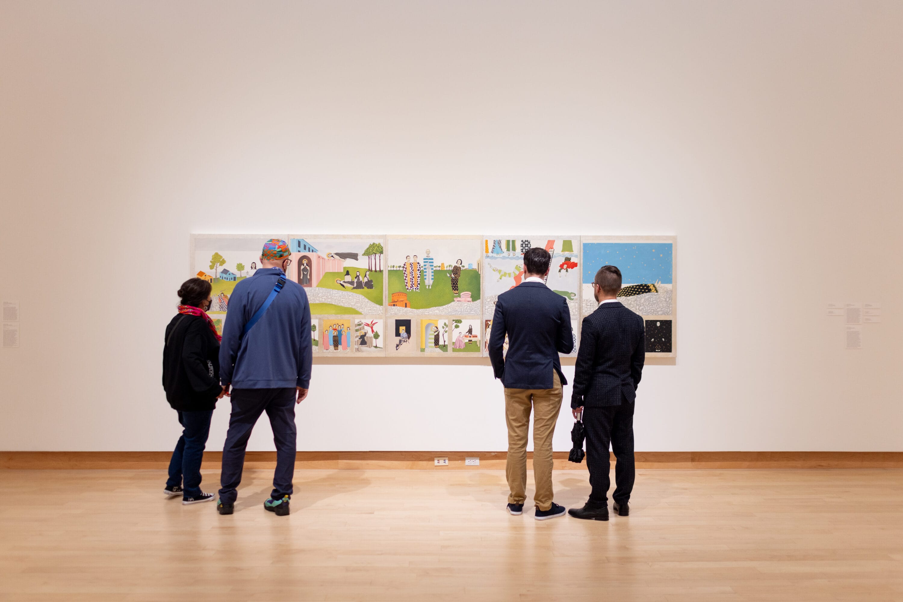 Four figures in a gallery looking at a painting.