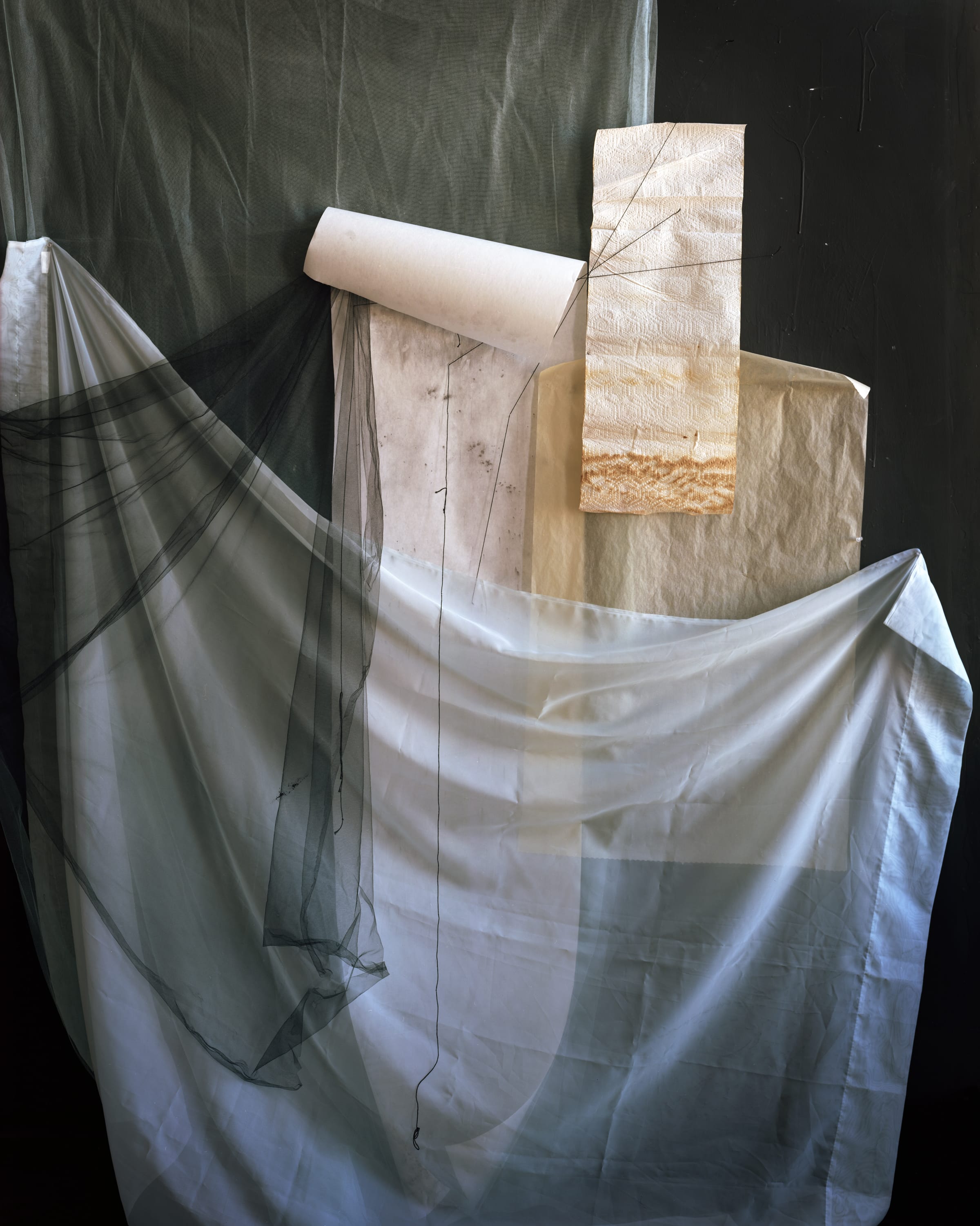 Sheets of think fabric pinned up next to a paper towel.