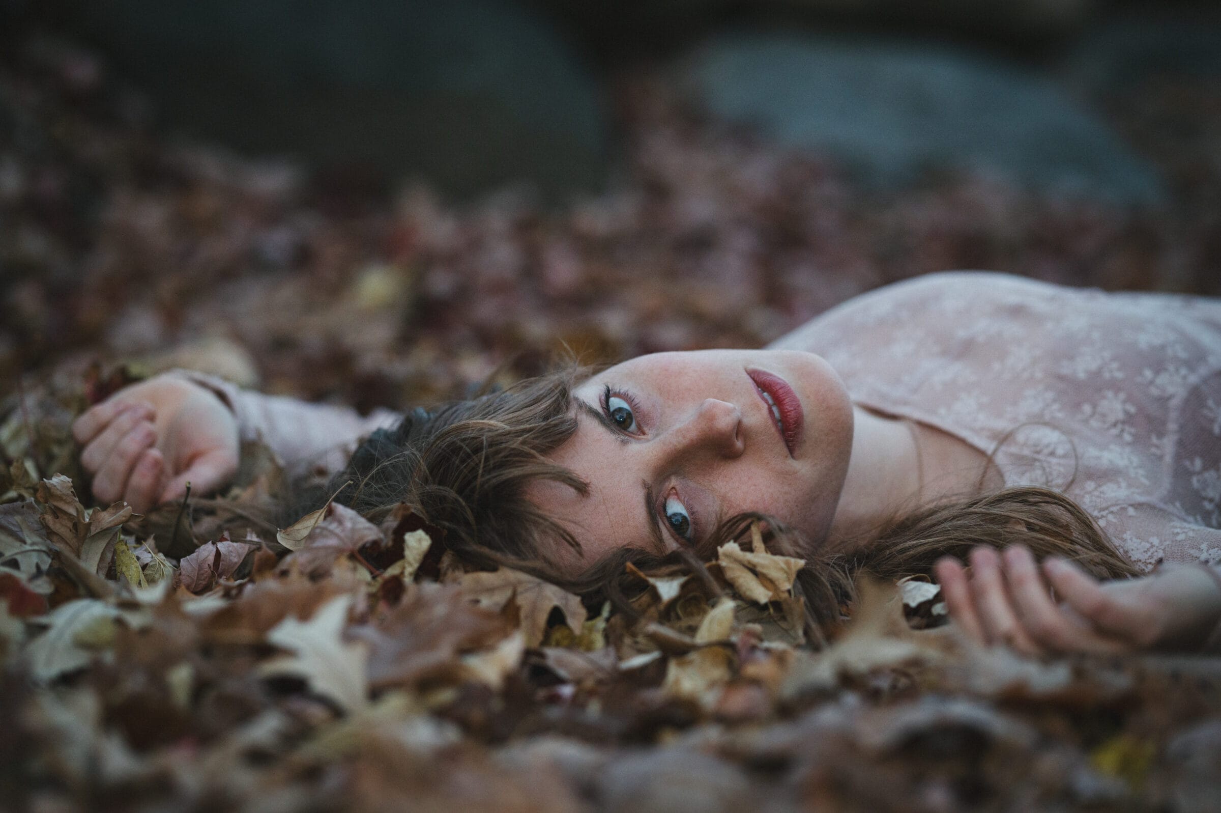A woman laying in leaves.