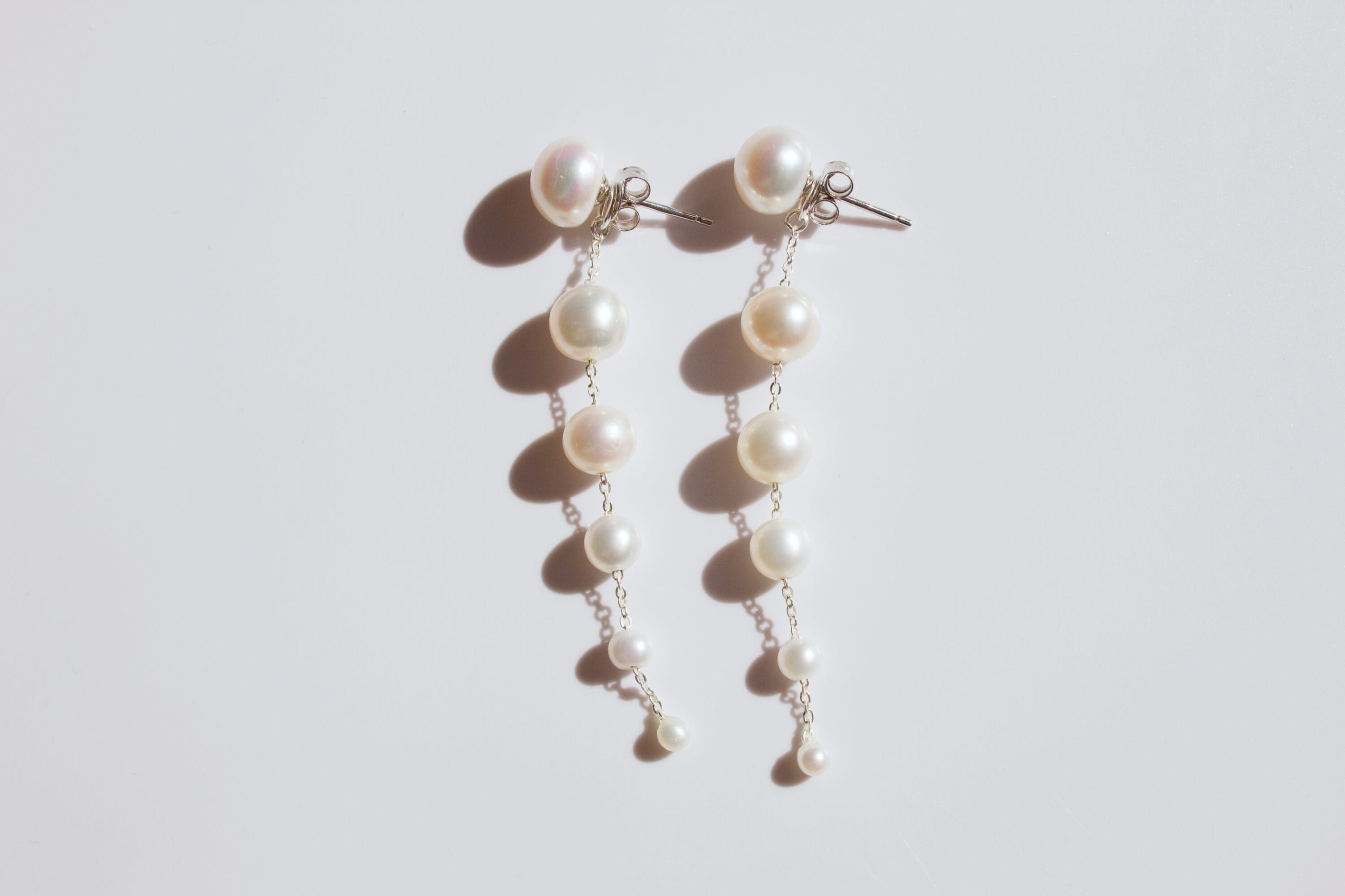 A pair of earrings with six pearls in diminishing size.
