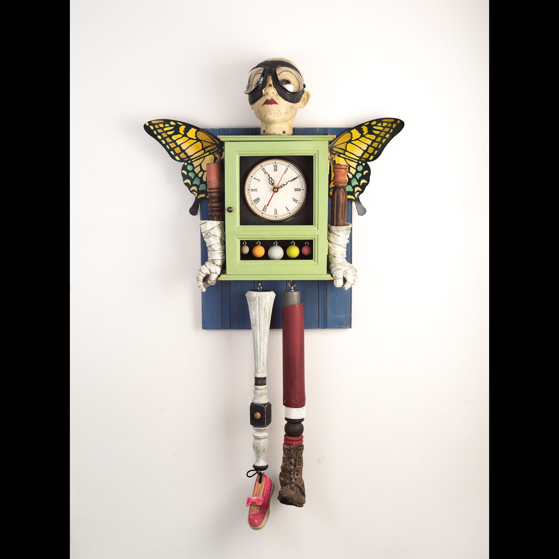 A sculpture of a figure with a clock body and butterfly wings.