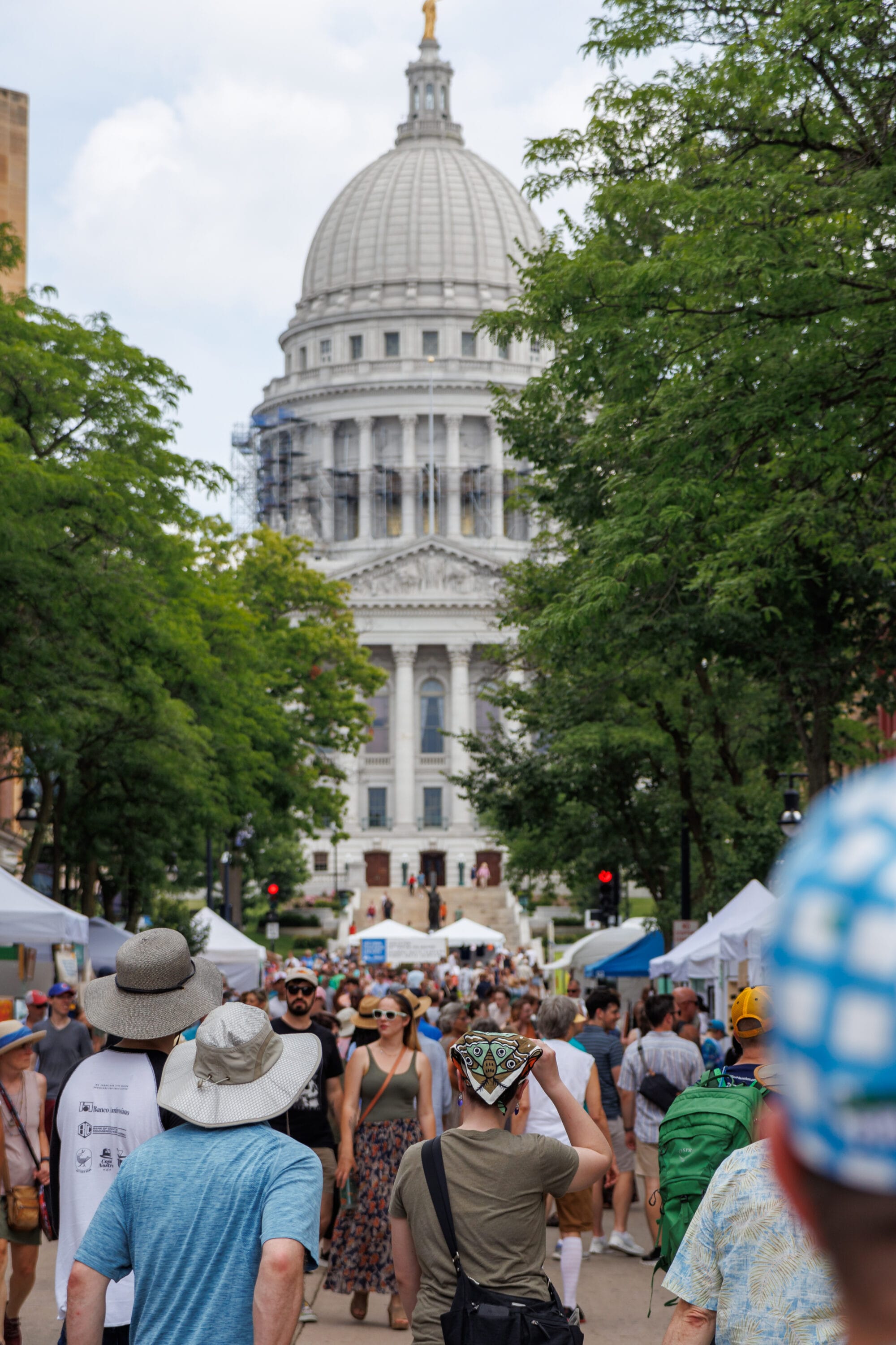 Numerous people walking by the Wisconsin State Capital.