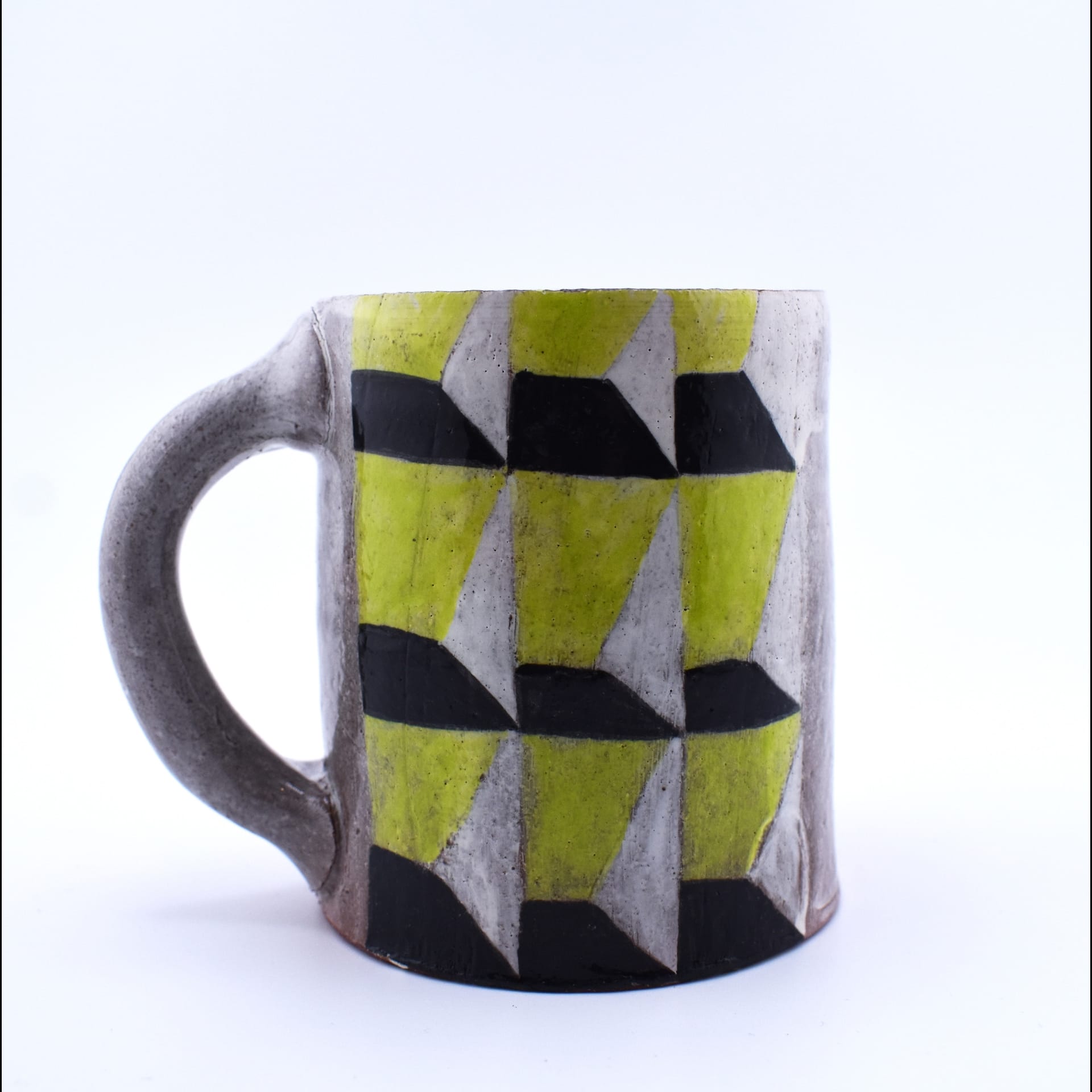 A mug with angular green patterns on it.