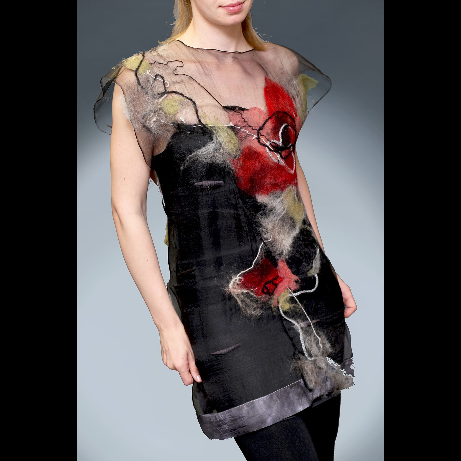 A woman wearing a sheer shawl with red flowers on it.