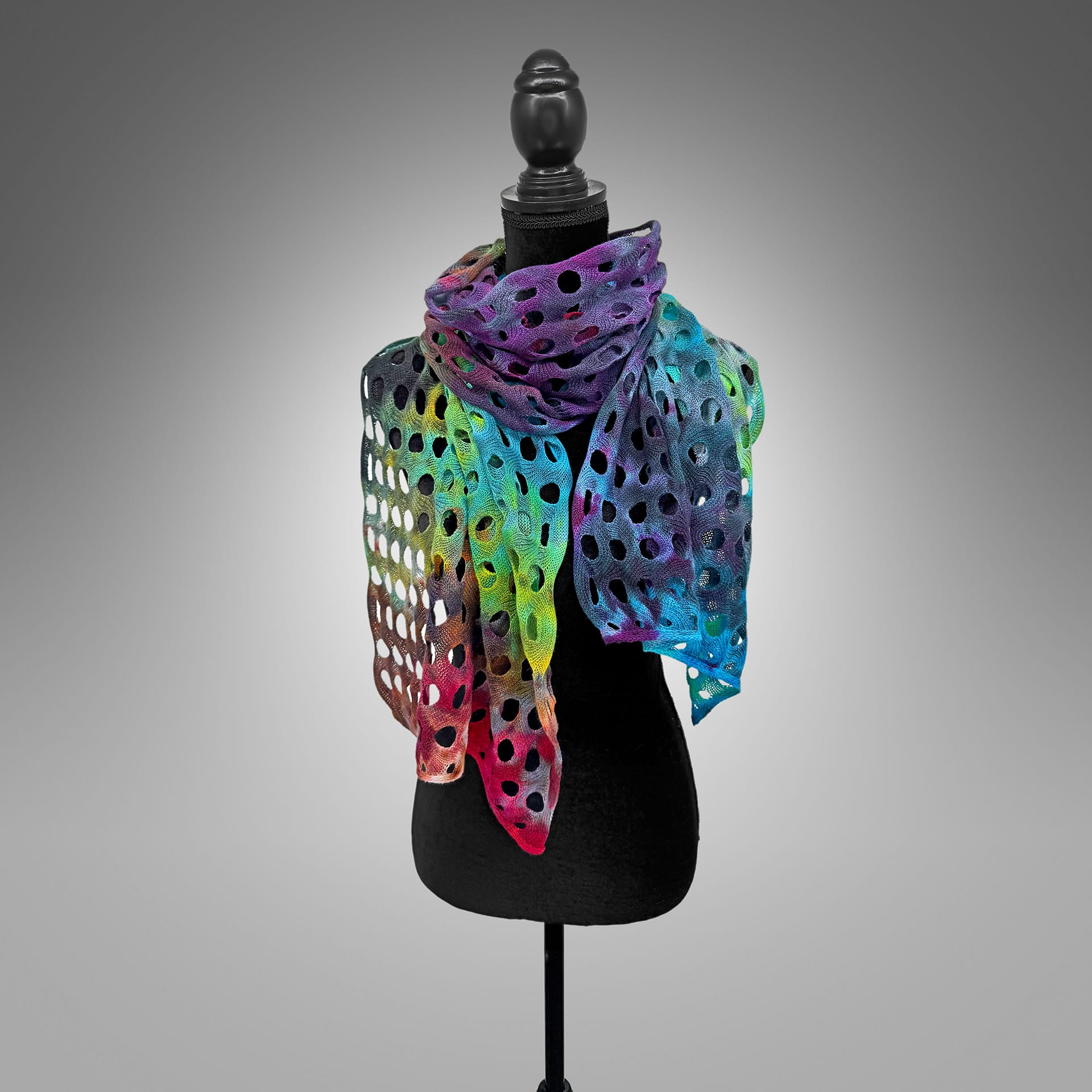 A colorful handmade scarf on a mannequin.