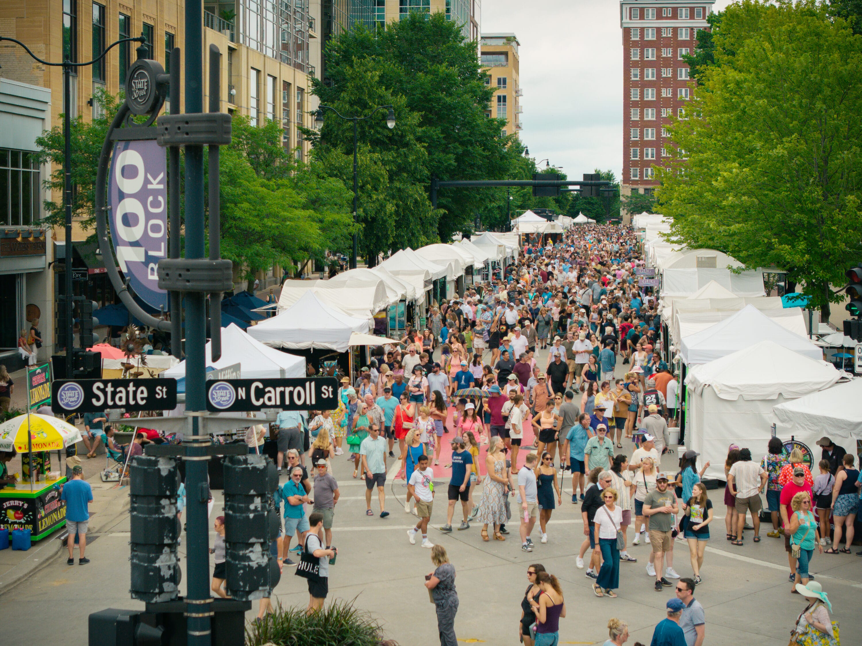 A crowd walking along artists booths.