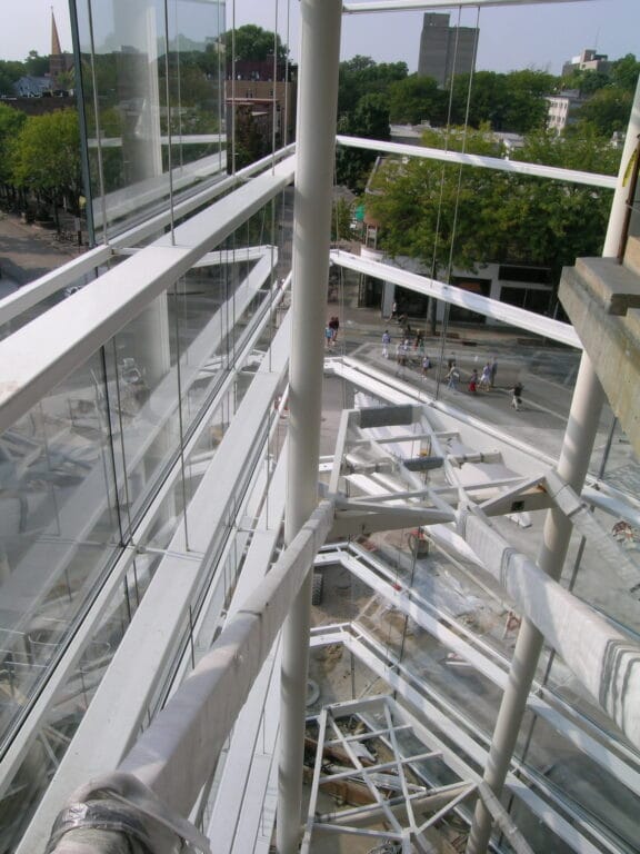 The interior of a window heavy building with the infostructure for stairs without the stairs.