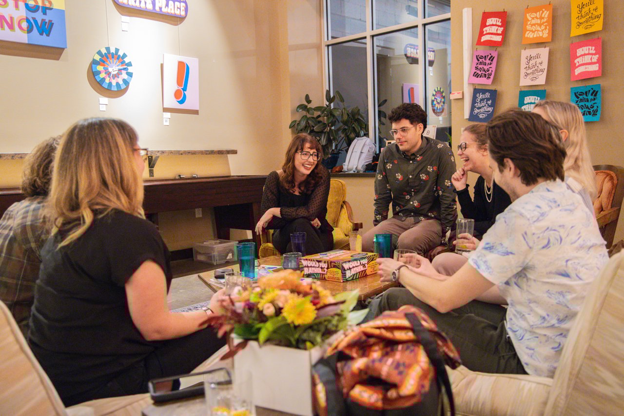 People sitting around a table smiling at each other.