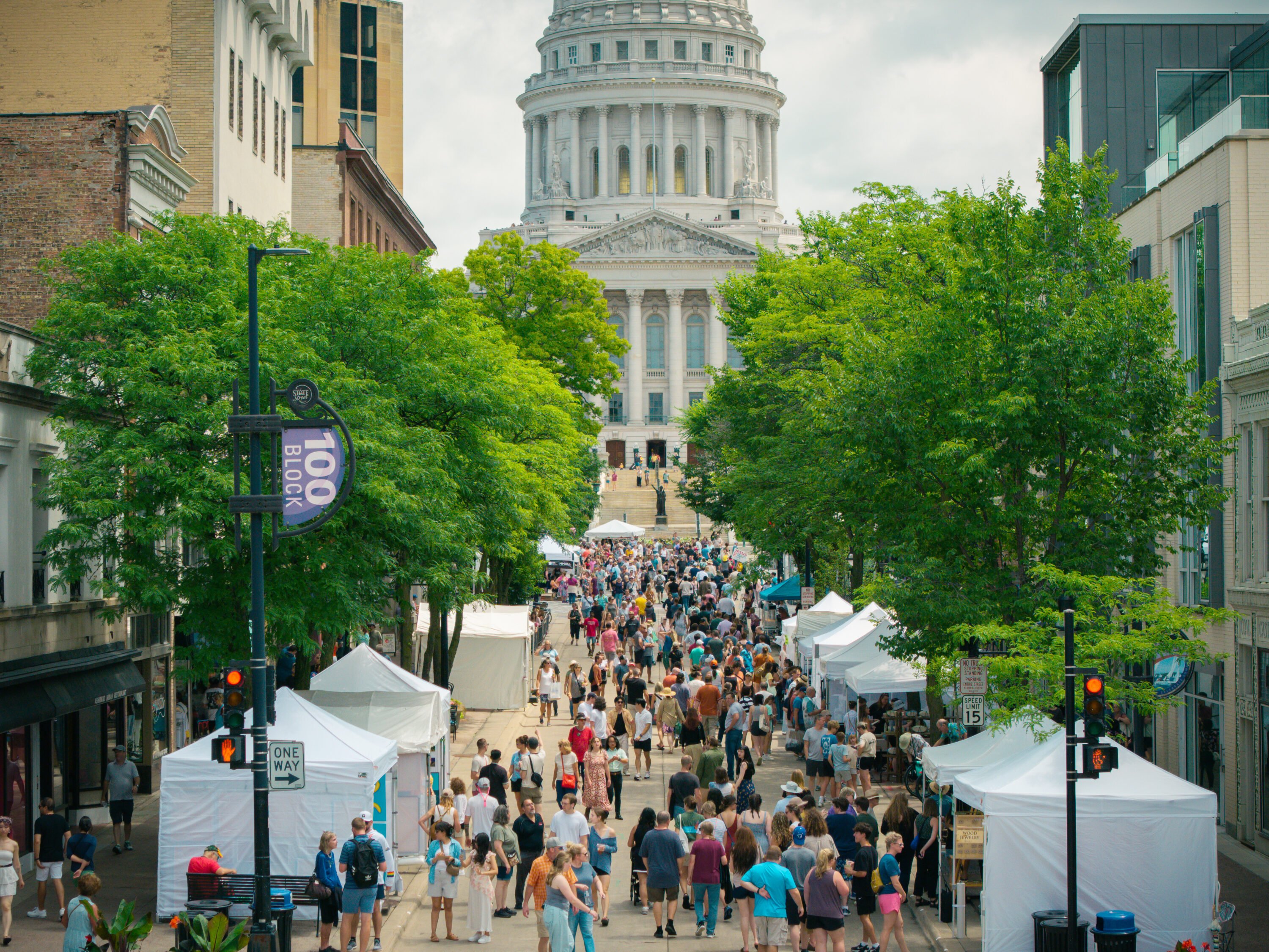 A crowd at art fair on the square with the Wisconsin State Capitol in the background