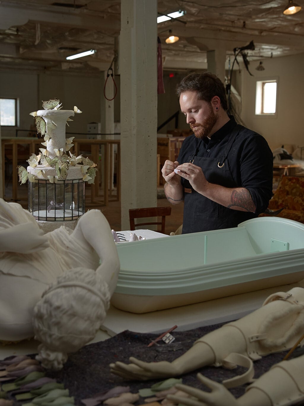 Artist David R. Harper in a studio space surrounded by sculptures