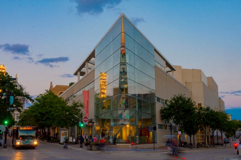 A glass angular building, the Madison Museum of Art, at sunset.